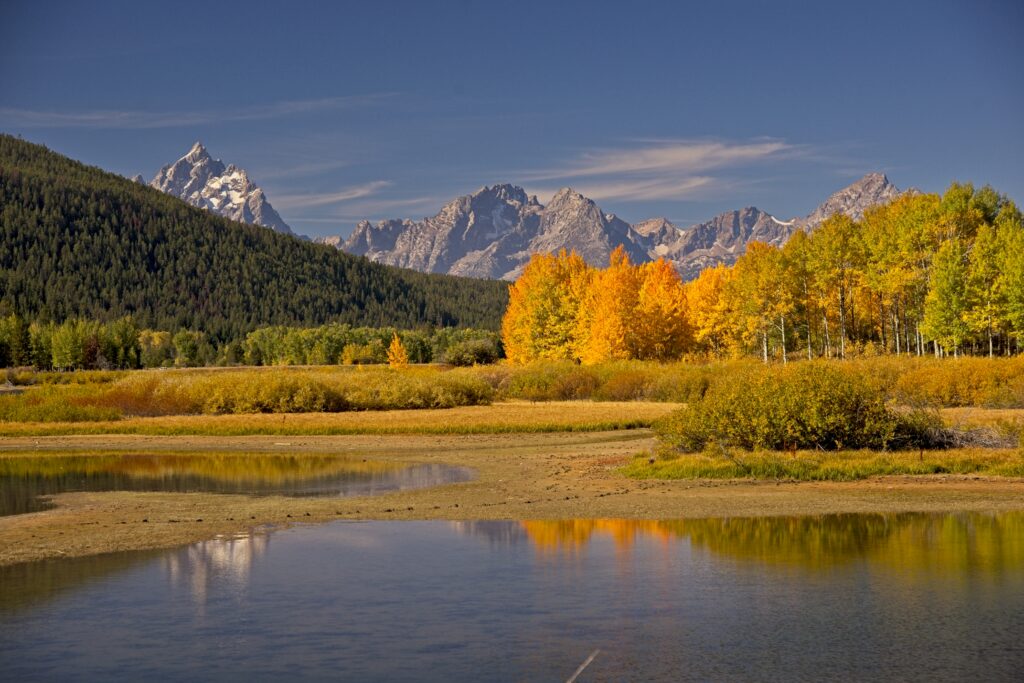 Autumn landscape with mountains and lake reflection.
